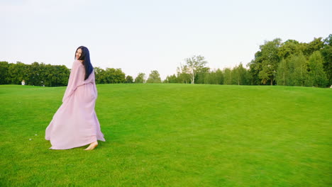 carefree pregnant woman in a light pink dress