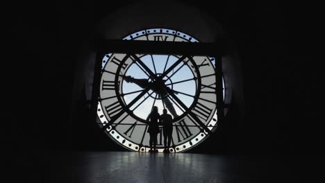 couple silhouette kissing in front of a clock in orsay museum, paris france