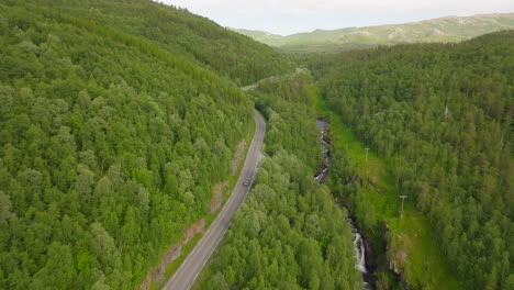 Campervan-Driving-On-The-Road-Along-The-Forest-And-Mountain-Valley-In-Norway