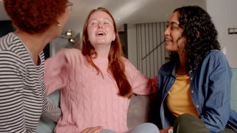 chatting and laughing, diverse female friends enjoying time together on couch indoors