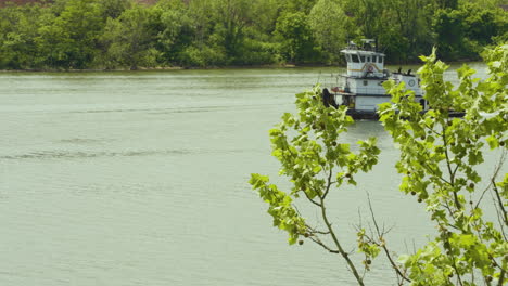 a tugboat entering the scene from the right as a small boat passes on a river in pennsylvania