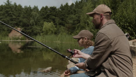 father and son fishing together by the lake