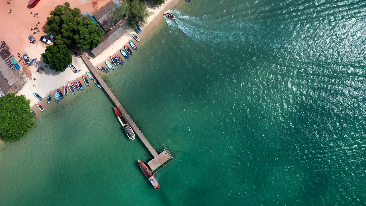 Droneoptagelse vertikalt ovenfra, der flyver over en mole på en strand i Cambodja.