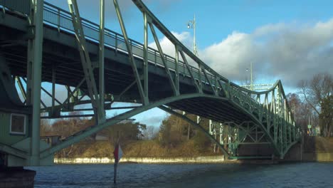 Oskara-Kalpaka-Metal-Swing-Bridge-at-Liepaja-shoot-from-Karosta-canal-bank-in-sunny-afternoon,-camera-tilt-up,-wide-shot