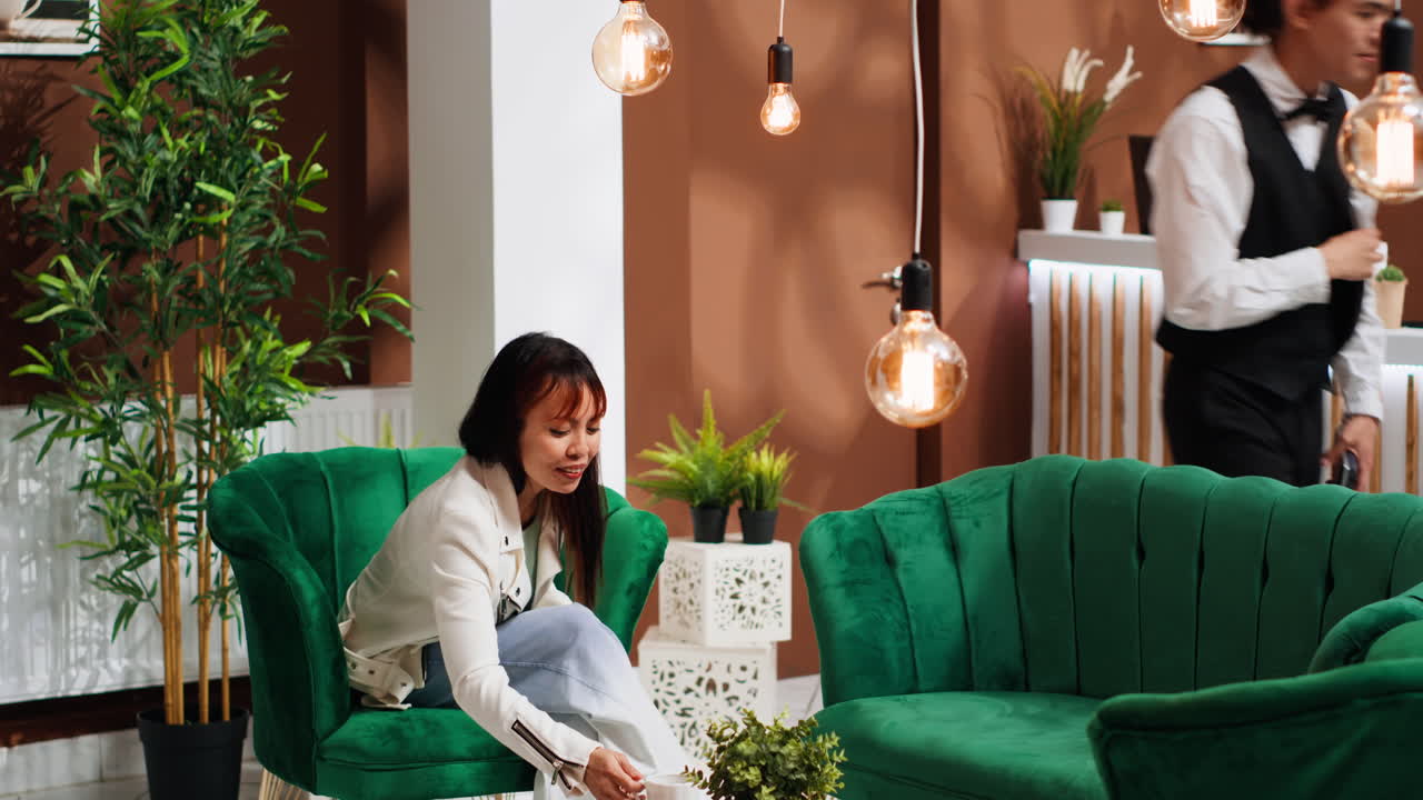 아시아 여성 이 라운지 에 있는 커피 주문 을 지불 하고 있다