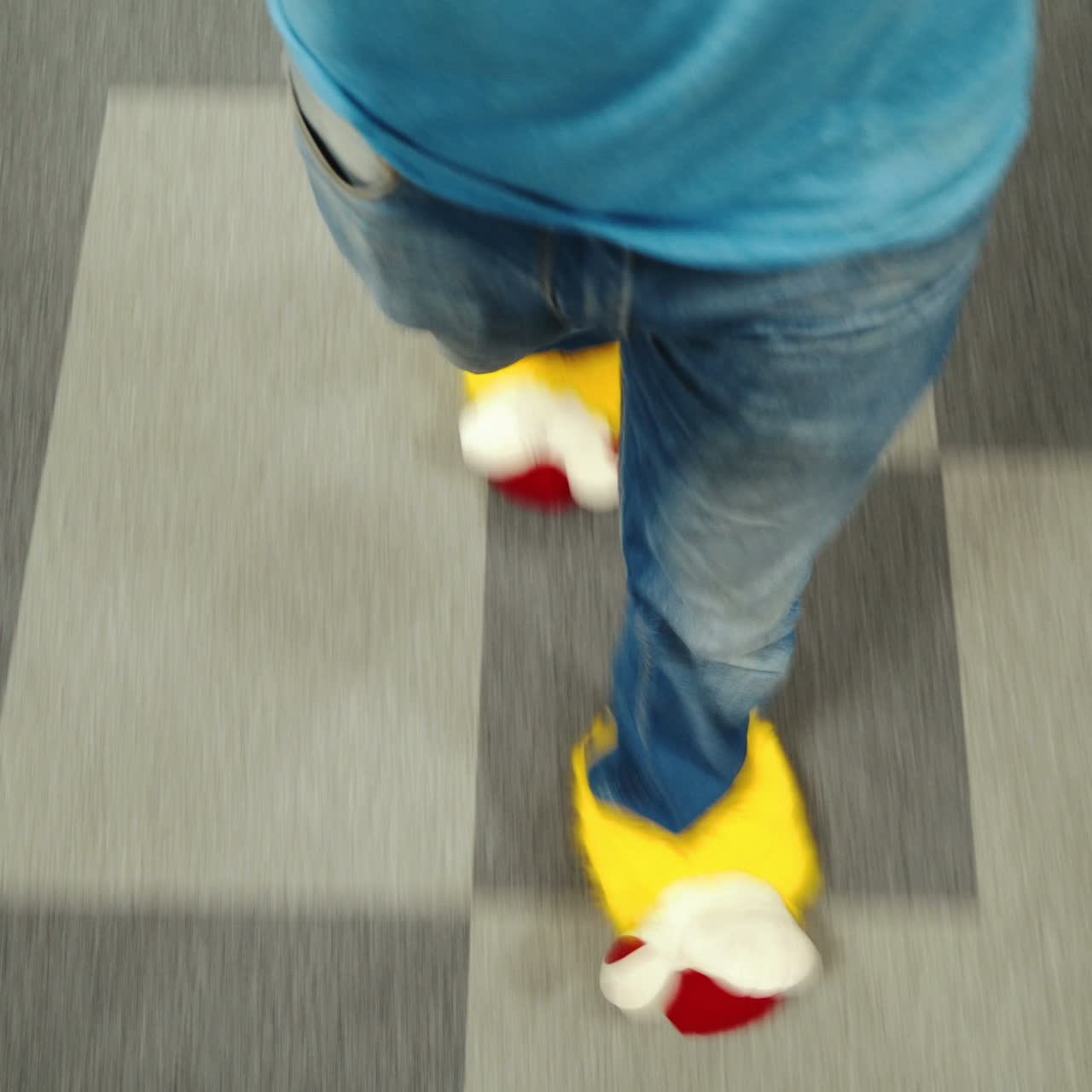 Office worker is running around in funny shoes. Male legs close-up walking around the office.