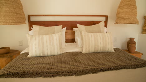 cozy bedroom with stylish pillows and woven lamp creating warm atmosphere, at home