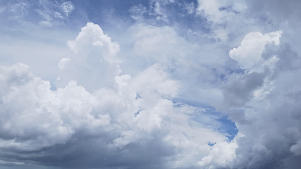 Big white swirling clouds drifting across a bright blue sky over the Philippines.