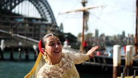 Mujer-Bailando-Danza-Clásica-India-Frente-Al-Puente-Del-Puerto-En-Sydney,-Australia---Cámara-Lenta