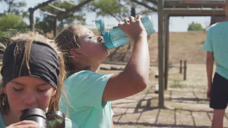 Chica-Caucásica-Bebiendo-Agua-En-El-Campo-De-Entrenamiento