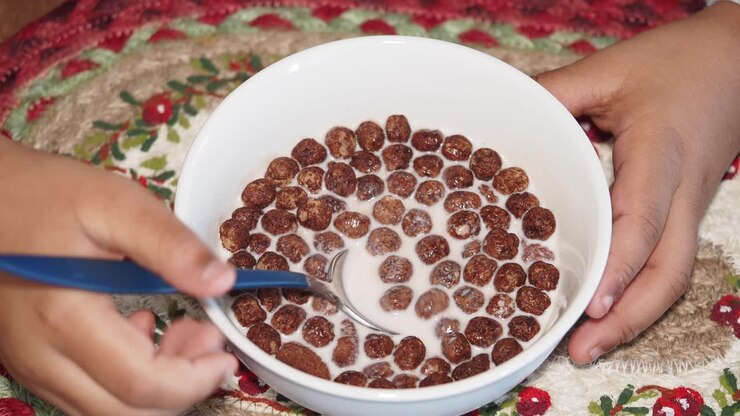 Bambino che mangia cereali al cioccolato