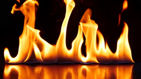 un primer plano de una llama de fuego en una superficie negra