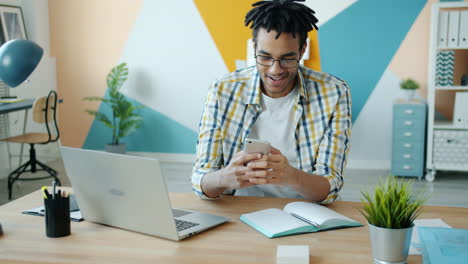 man working at desk with laptop and smartphone