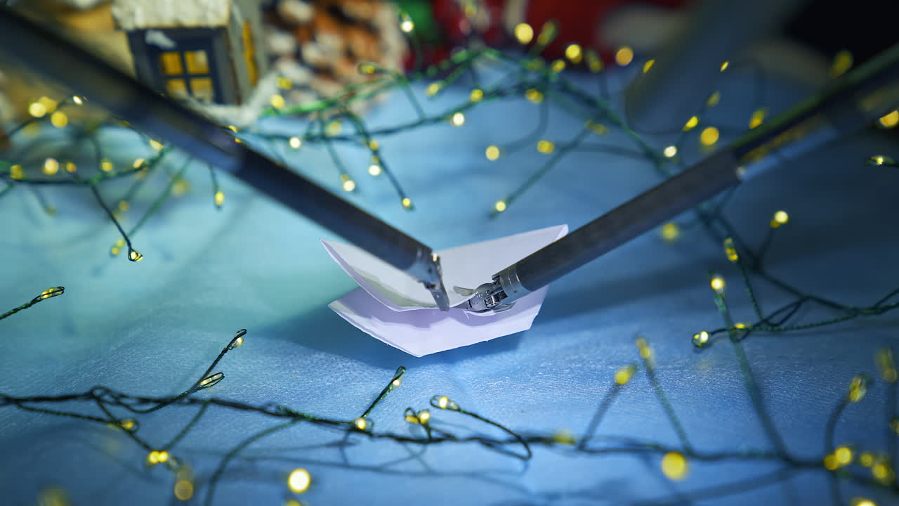 Artificial intelligence robot preparing snowflake from paper while preparing to the Christmas. Cropped view