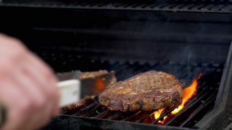 Two-raw-rib-eye-steaks-cooking-on-a-grill