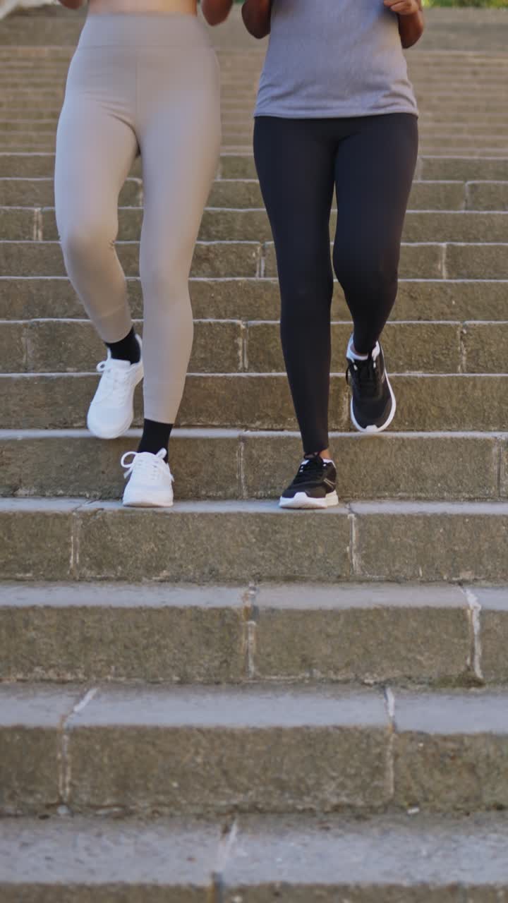 Due persone che scendono scale di pietra con le scarpe da ginnastica