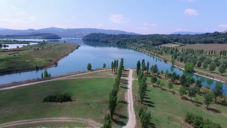 Aerial-descent-in-the-rural-region-of-the-Tuskany-in-Italy-on-a-sunny-day-with-a-lake-in-the-back