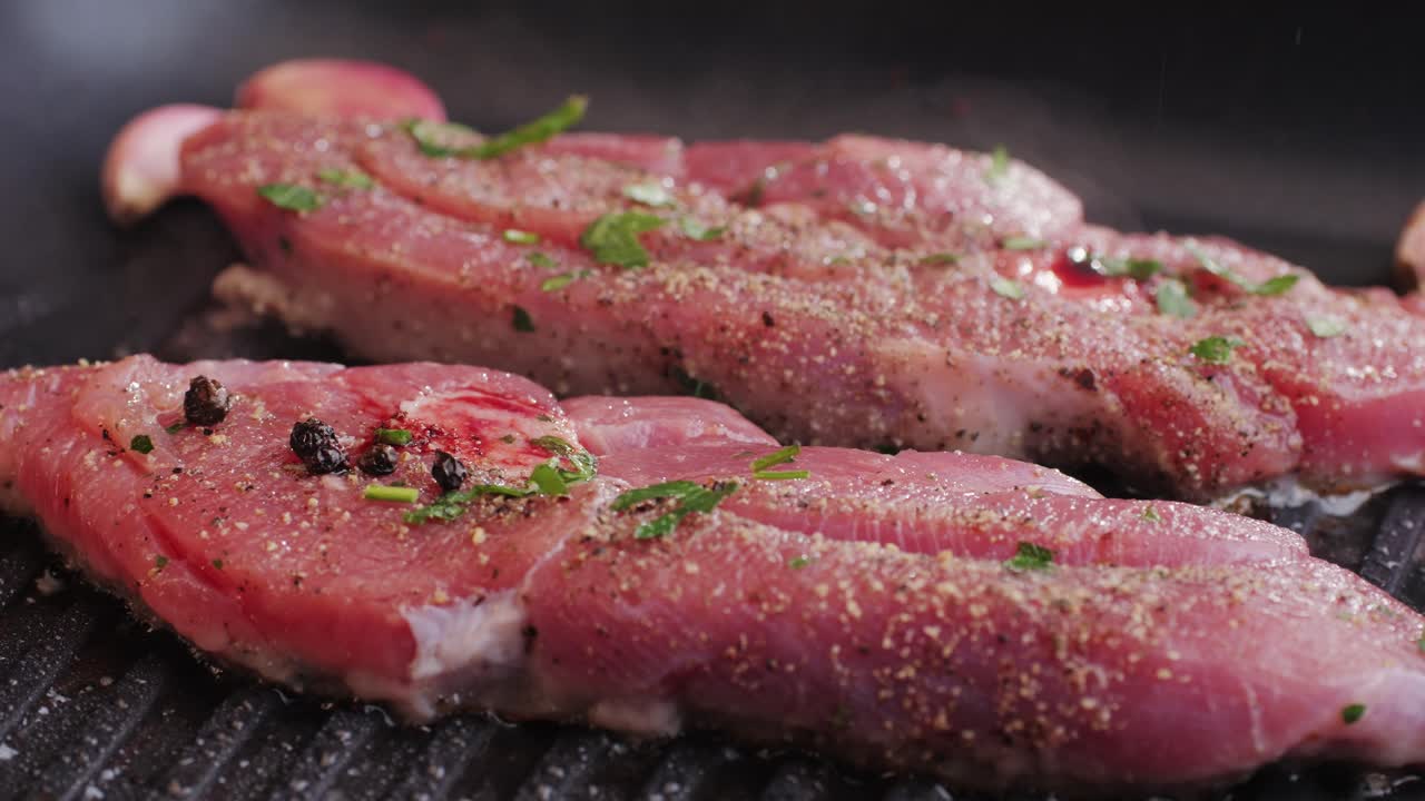 Cooking raw turkey meat in spices with garlic and greens on grill close-up. Fry chicken or turkey slice on frying pan Grilled chicken, duck, turkey kebab with vegetables.