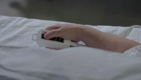patient using hospital bed remote control