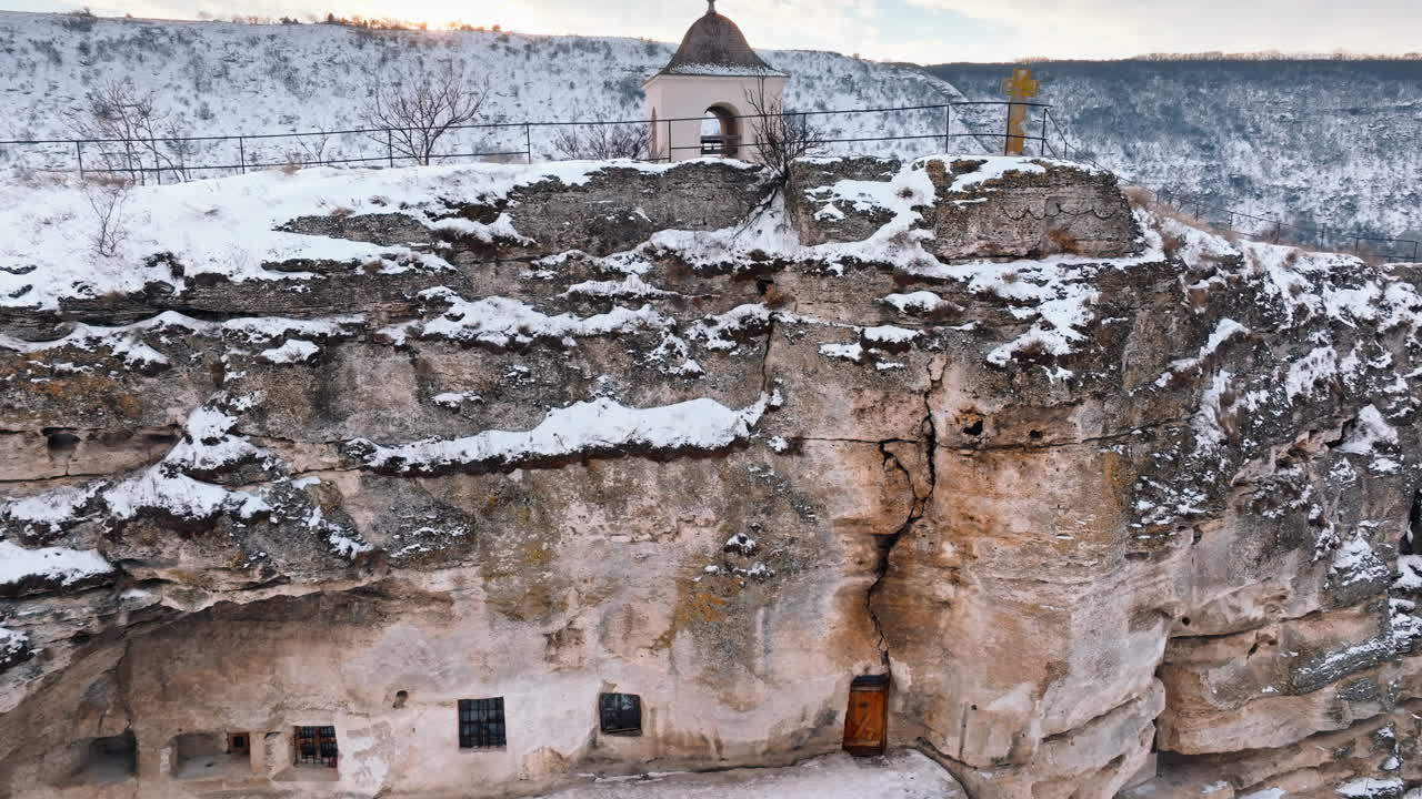 Aerial drone view of the cave monastery in Old Orhei at sunrise. City covered in snow. Moldova