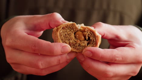 person holding a piece of baklava