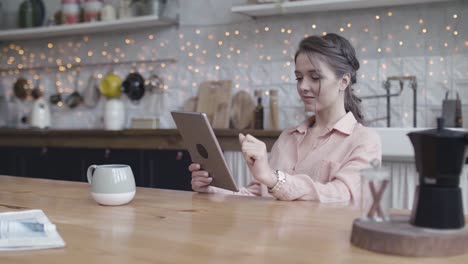 woman using tablet in a cozy kitchen