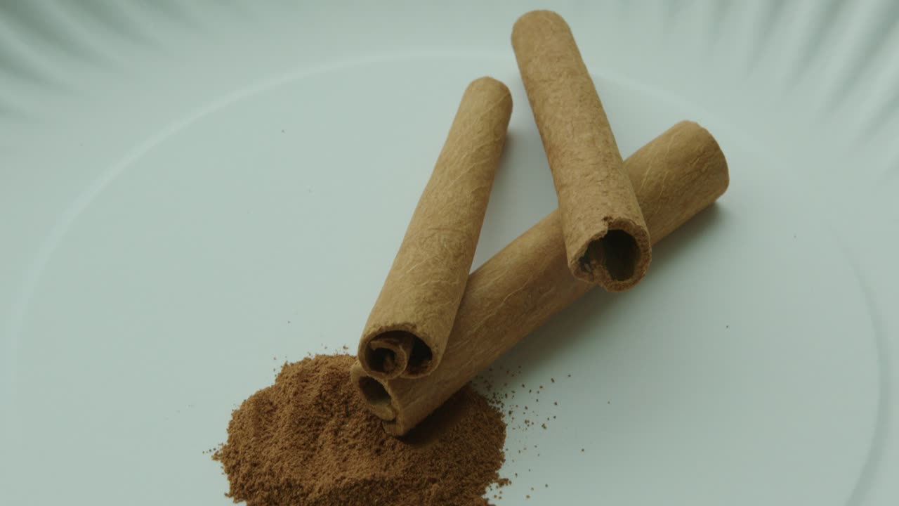 Nærbilde, tilt ned, av kanelstenger og malt kanel.