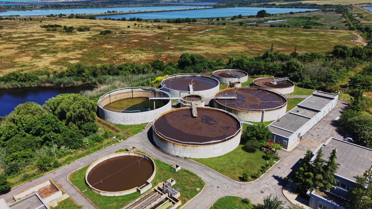 Water treatment facility near river in a green landscape during daytime