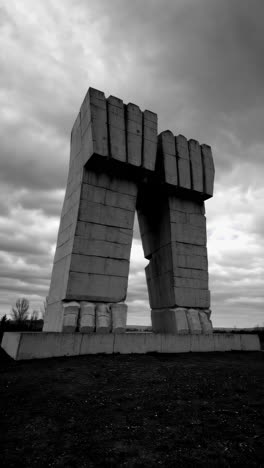 brutalist concrete fists monument under cloudy sky