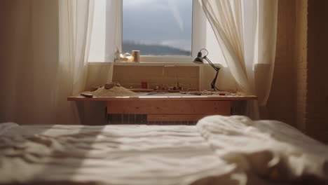cozy bedroom with unmade bed and desk by window