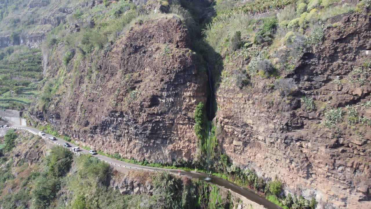 una magnífica cascada que cae sobre una carretera en madeira