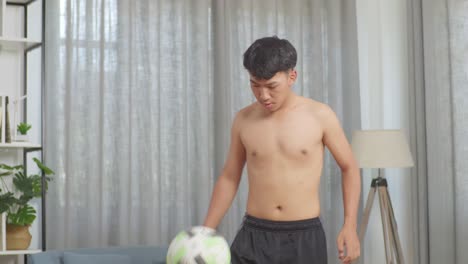 asian teenager boy doing football skills during the shirtless workout at home