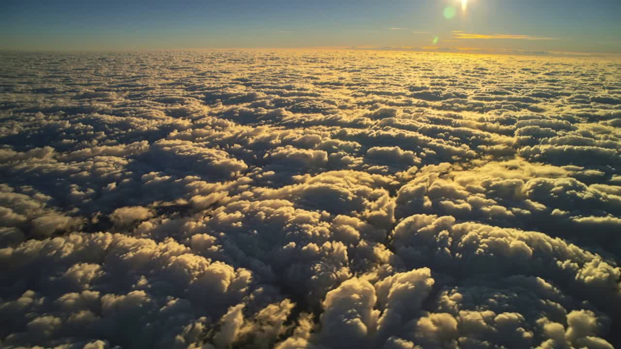 Drone che scende sopra un banco di nuvole, il sole crea un bagliore sull'obiettivo e rivela le creste delle nuvole per uso aeronautico.