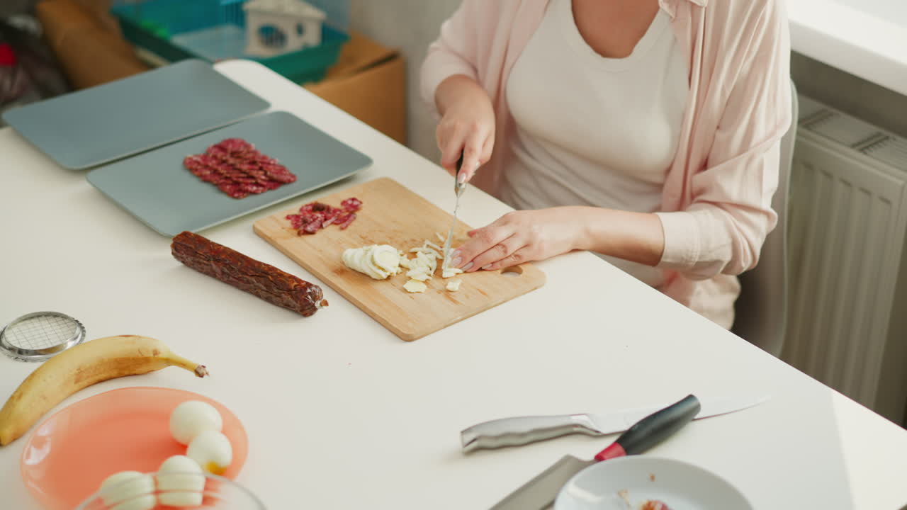 Woman Chopping Eggs and Sausage for a Meal