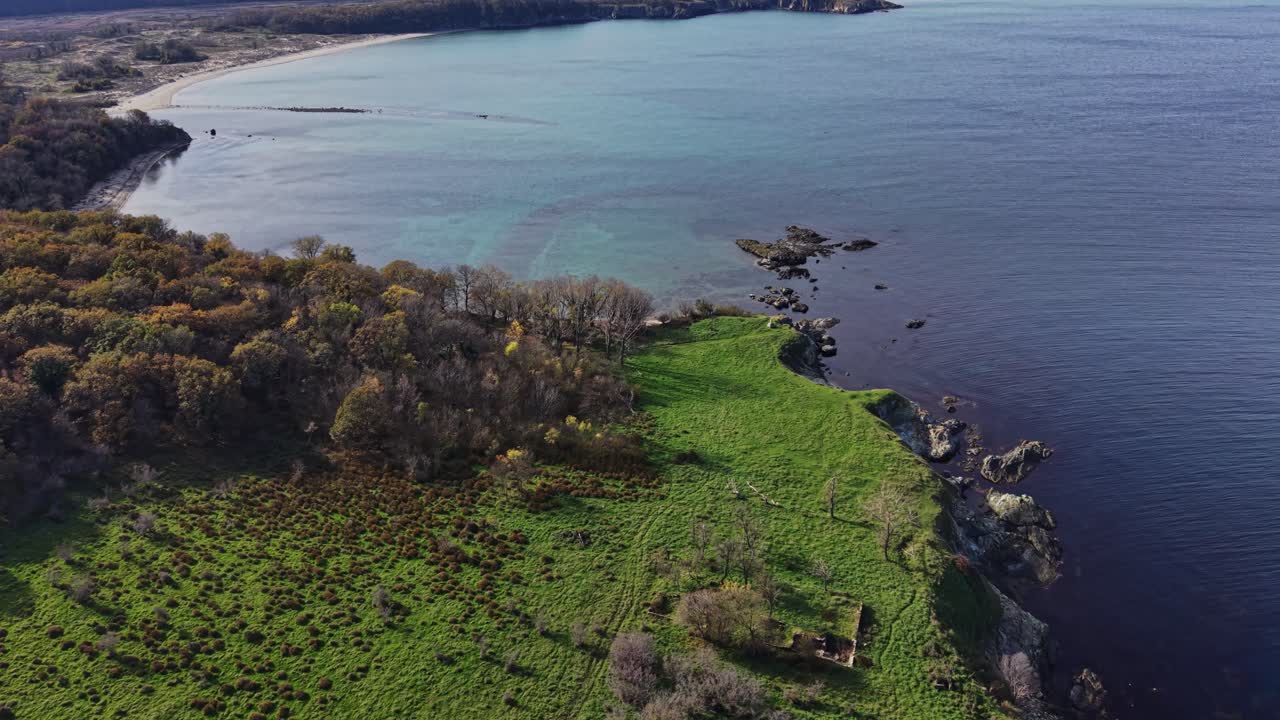 Aerial view of coastal land with rocky cliffs and lush greenery
