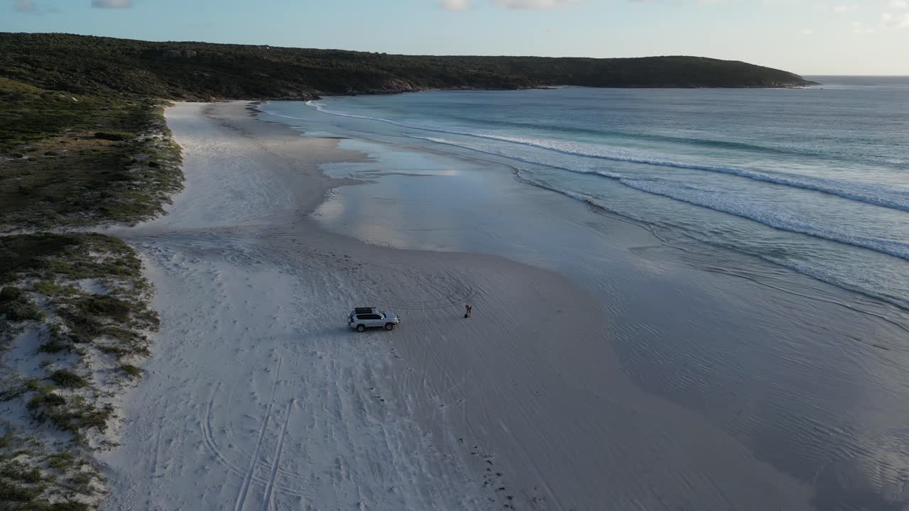 Ripresa aerea orbitante di un veicolo 4x4 parcheggiato su una spiaggia in Australia