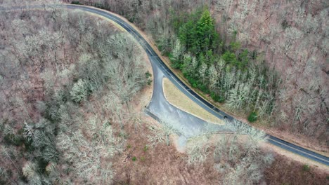 car leaving forest hillside parking lot and continues road trip