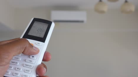 person using an air conditioner remote