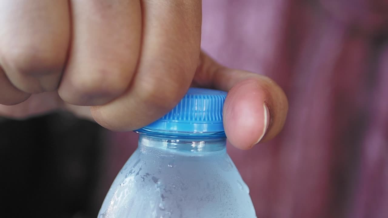 persona que abre una botella de agua