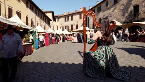 woman playing harp at an outdoor festival or medieval fair