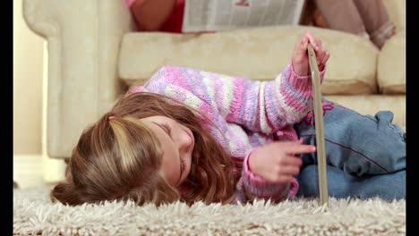 Little-girl-using-tablet-on-floor