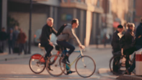 anonymous crowd of people walking cycling bicycles commuters london city street slow motion