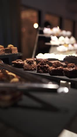 variety of chocolate pastries are displayed on a tiered stand in a bakery, showcasing an assortment of delicious treats