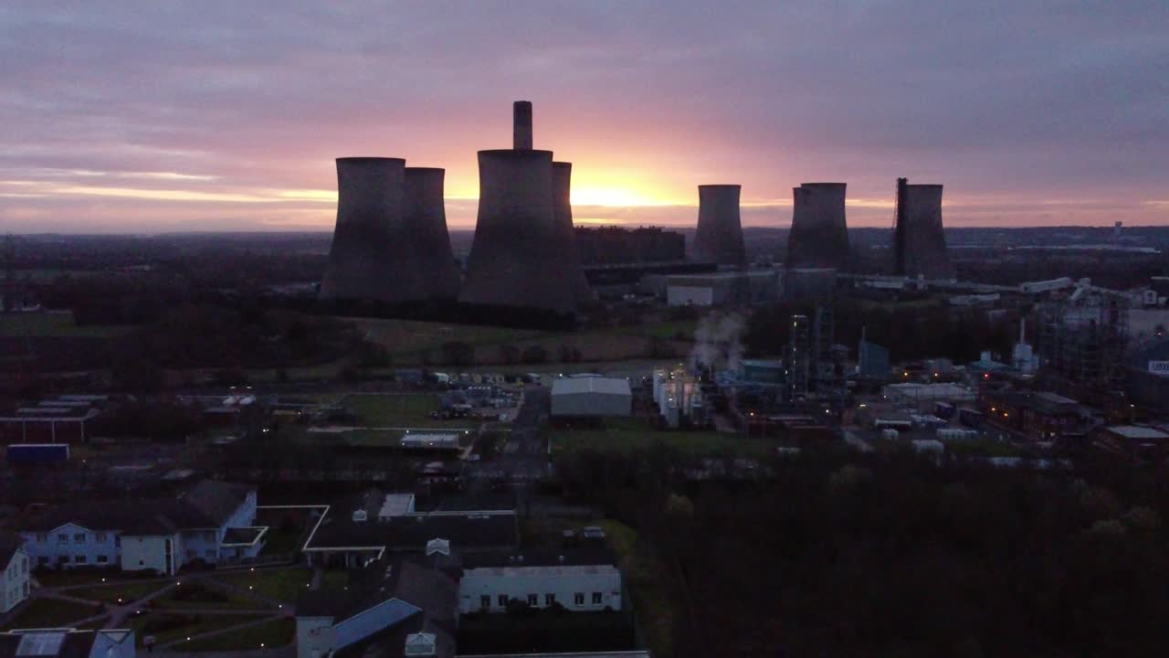 fiddlers ferry central eléctrica alimentada con carbón en desuso al amanecer brillando detrás de warrington landmark, vista aérea órbita derecha
