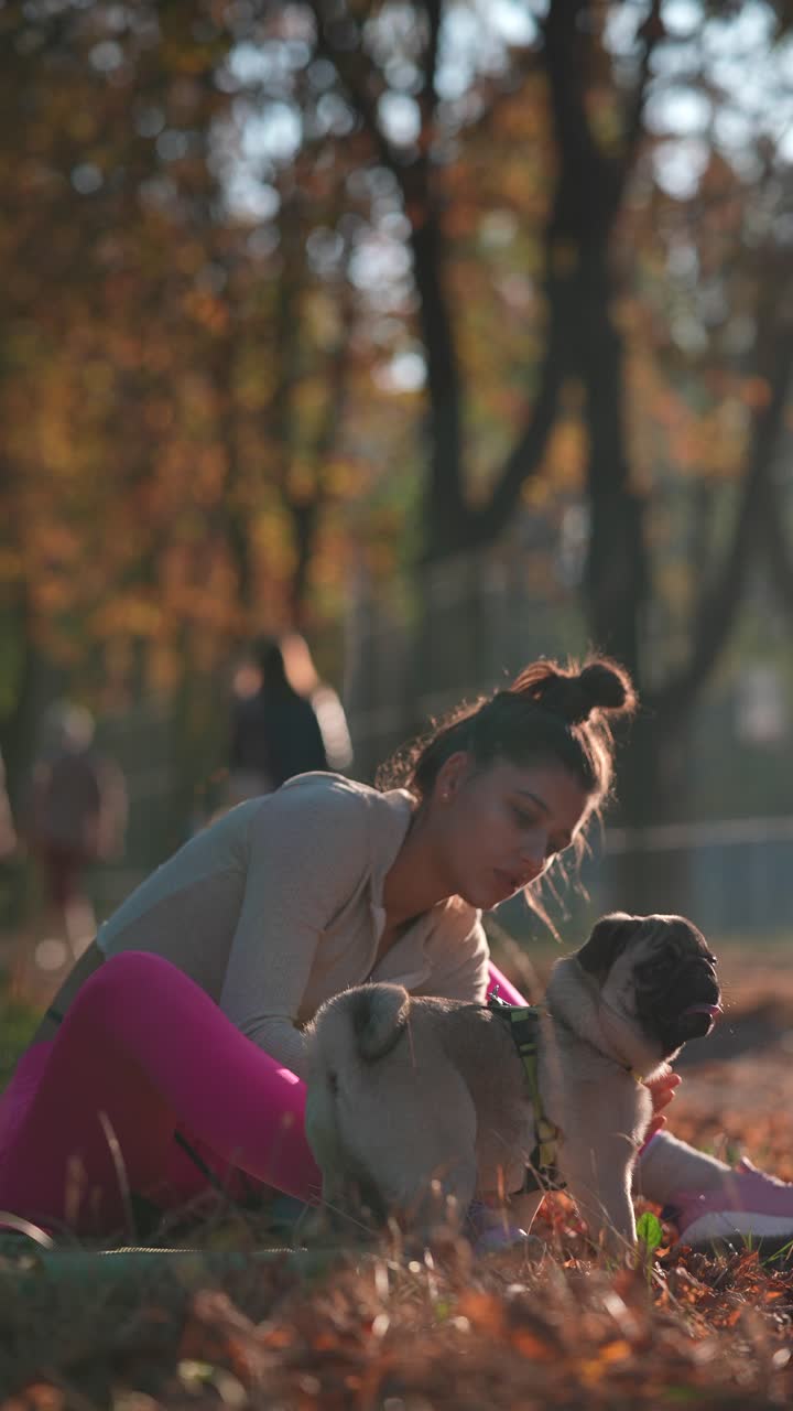 y mujer pug en el parque de otoño