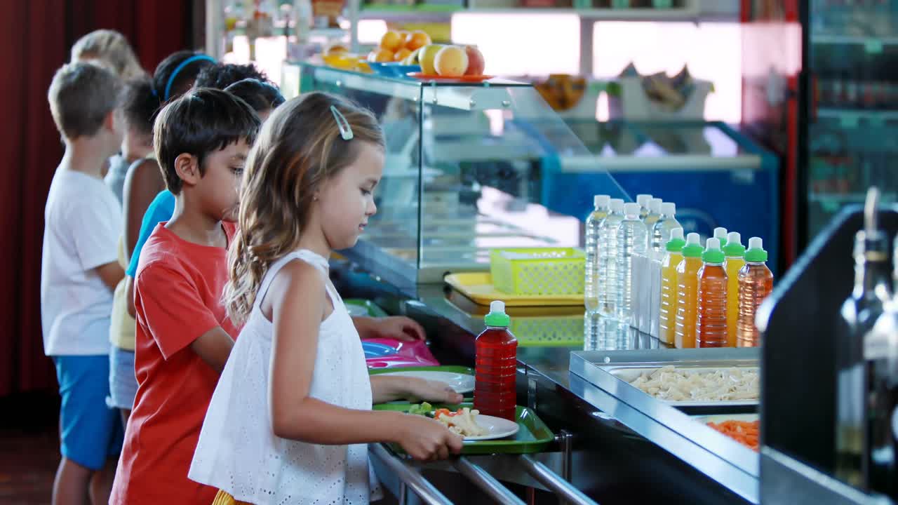 Bambini che prendono il pasto dal bancone