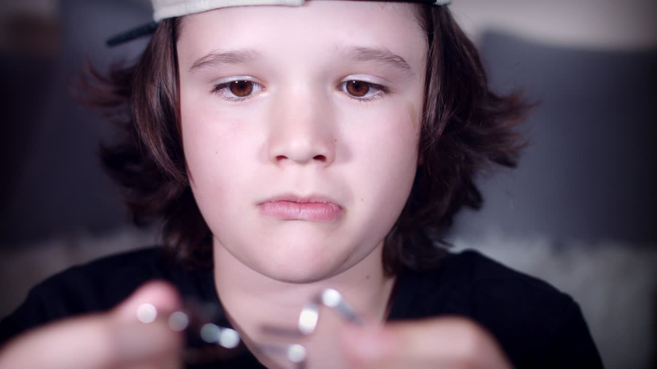 4k의 아이의 손이 머릿속을 괴롭히기 위해 금속 퍼즐을 가지고 놀고 있습니다.