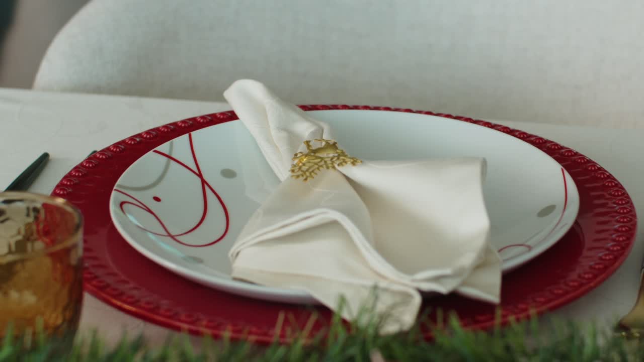 festive table setting with red charger white napkin and holiday decor