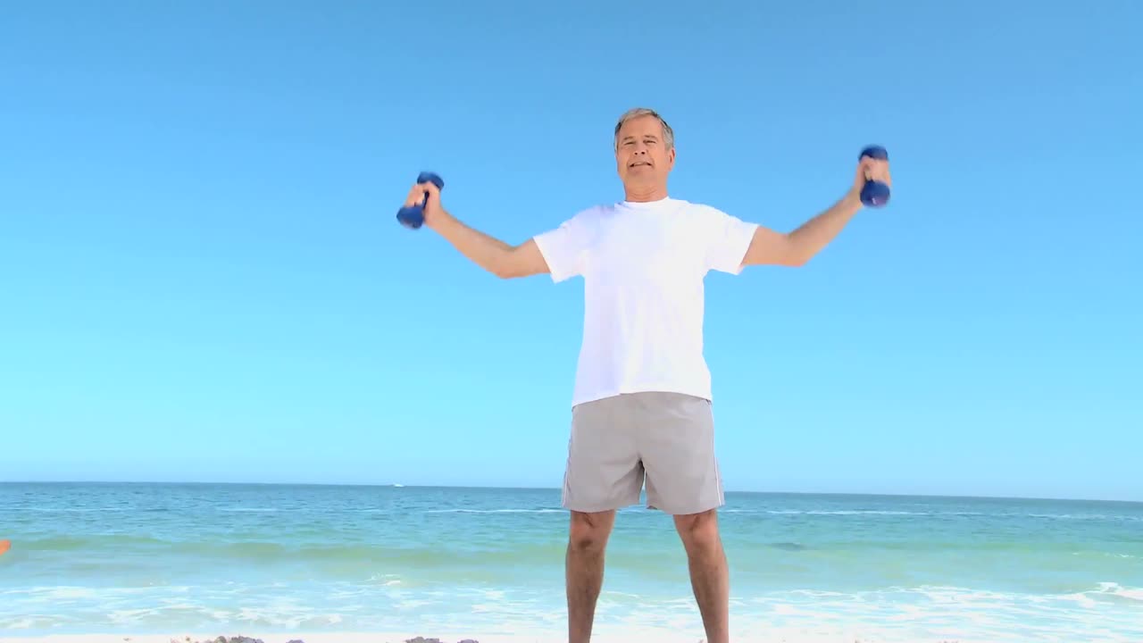 성숙 한 남자 는 덤벨 으로 근육 을 운동 시키고 있다