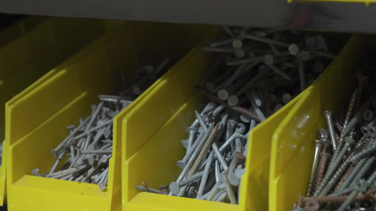 Various fasteners sorted into bins on a workbench.